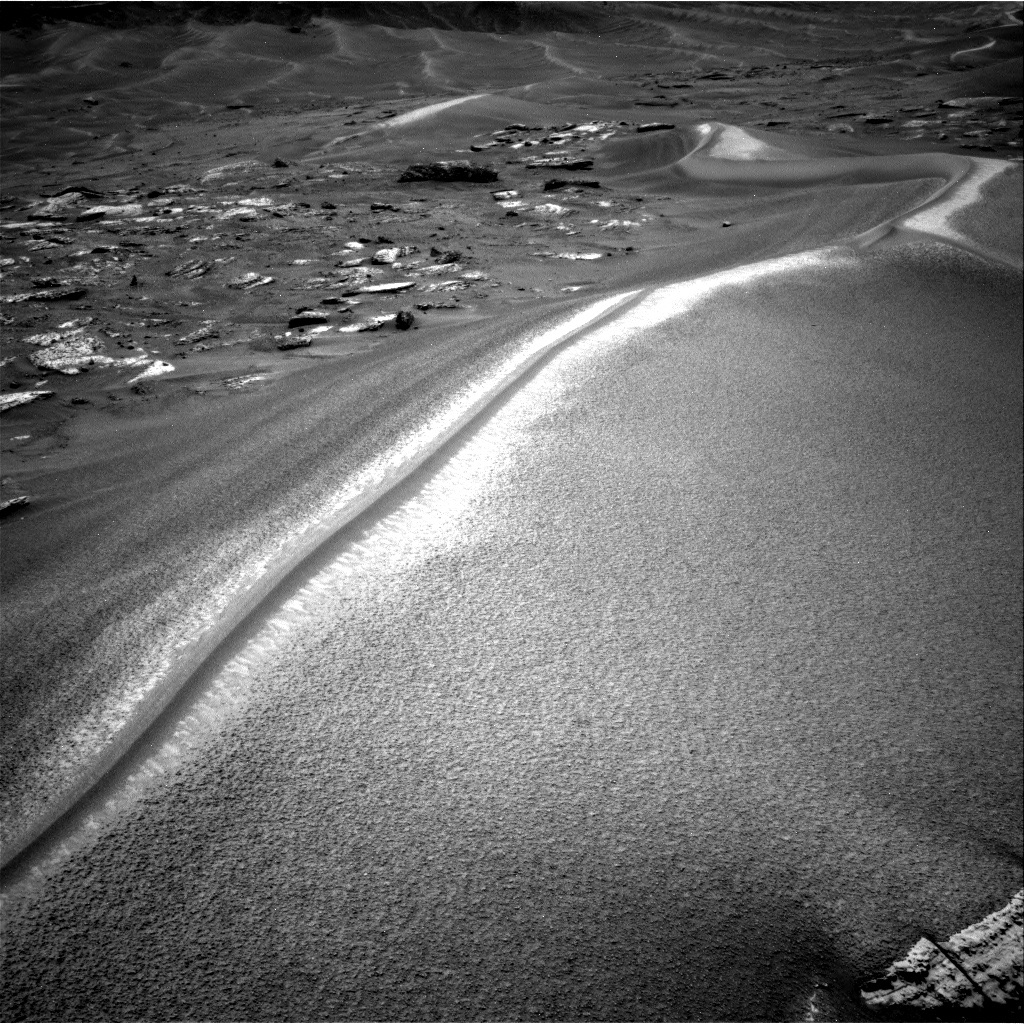 Monochrome Navigation Camera view of the narrow Chocolatal sand ripple crossing rocky terrain on Mars