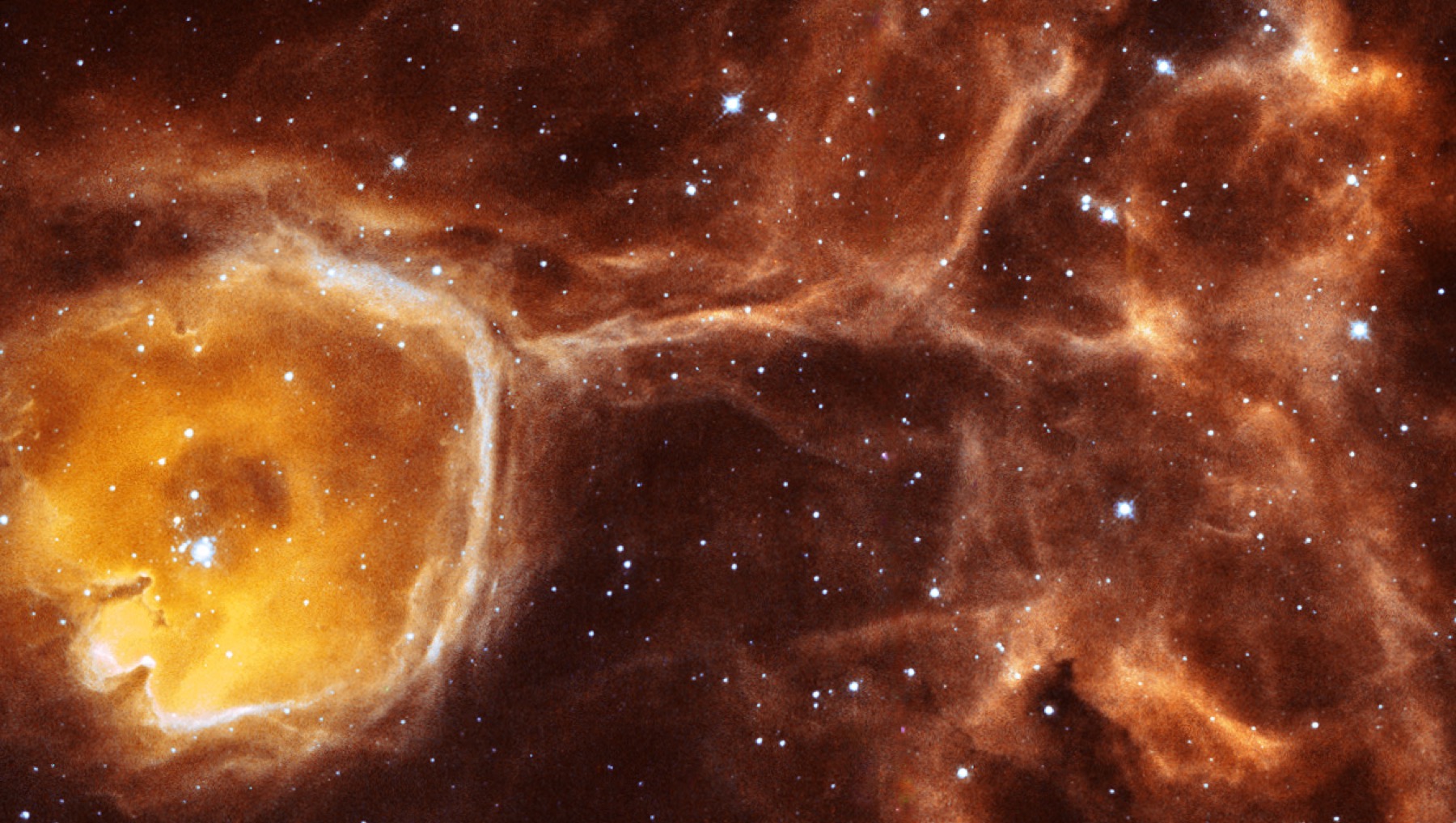 A Hubble close-up of the smaller N44F bubble with glowing red gas, blue edges, dark pillars, and a bright central star