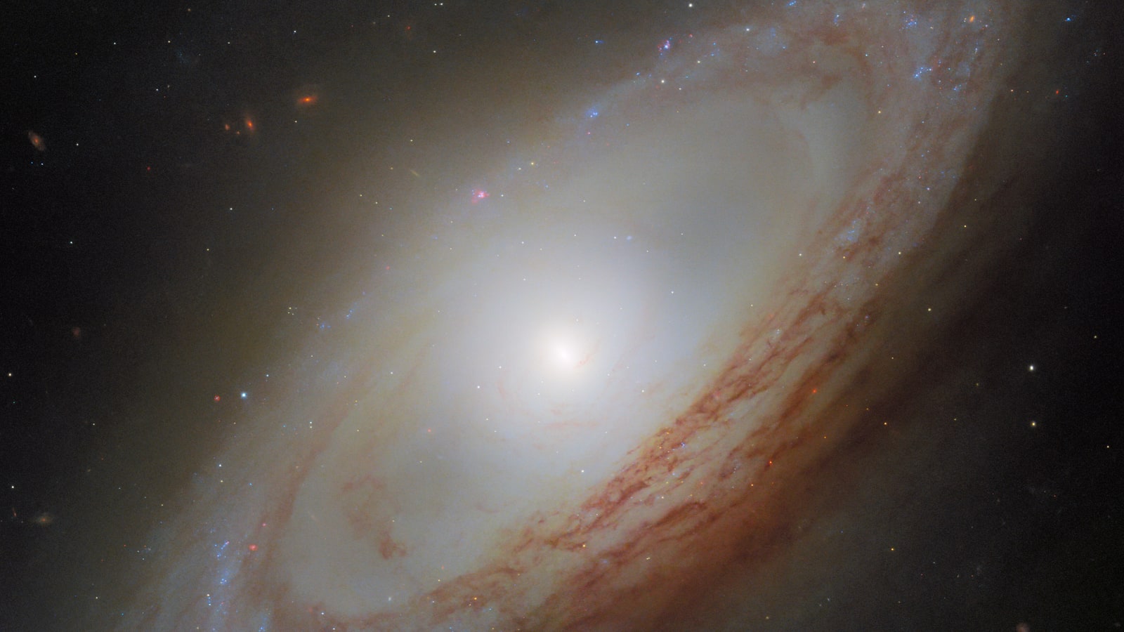 Hubble view of NGC 4698, a tilted spiral galaxy with dusty outer arms surrounding a bright elongated center