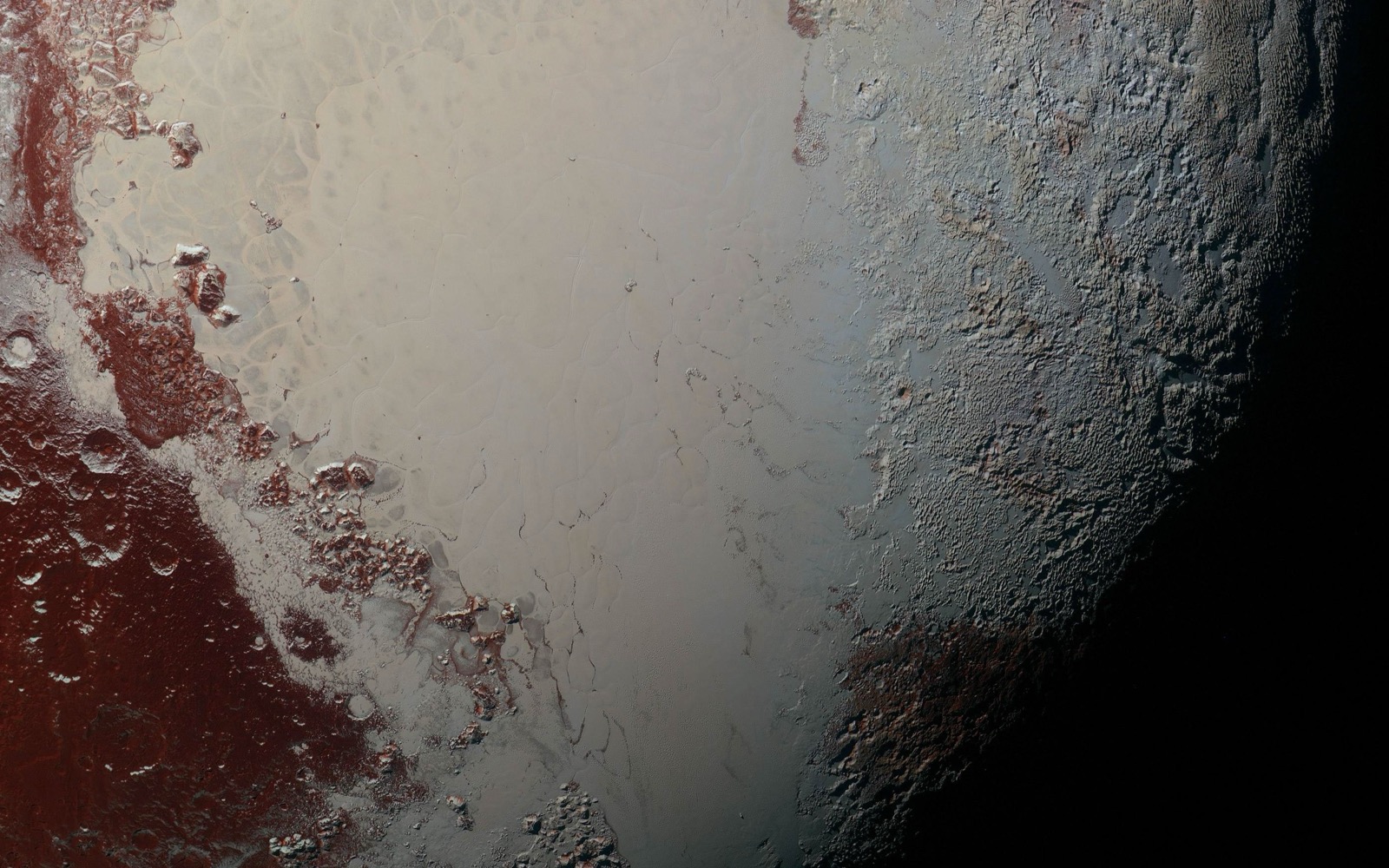 A documentary crop of the enhanced-color Pluto image centered on the two lobes of the bright heart-shaped Tombaugh Regio