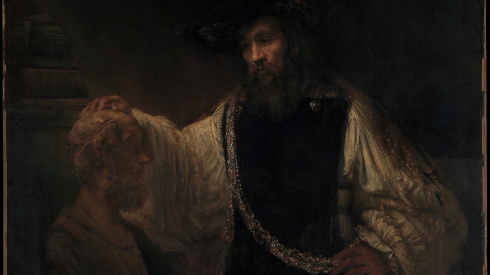 Cropped view of Rembrandt’s dark 1653 painting showing Aristotle in a black hat resting one hand on a sculpted bust of Homer while a heavy gold chain and medallion cross his chest.