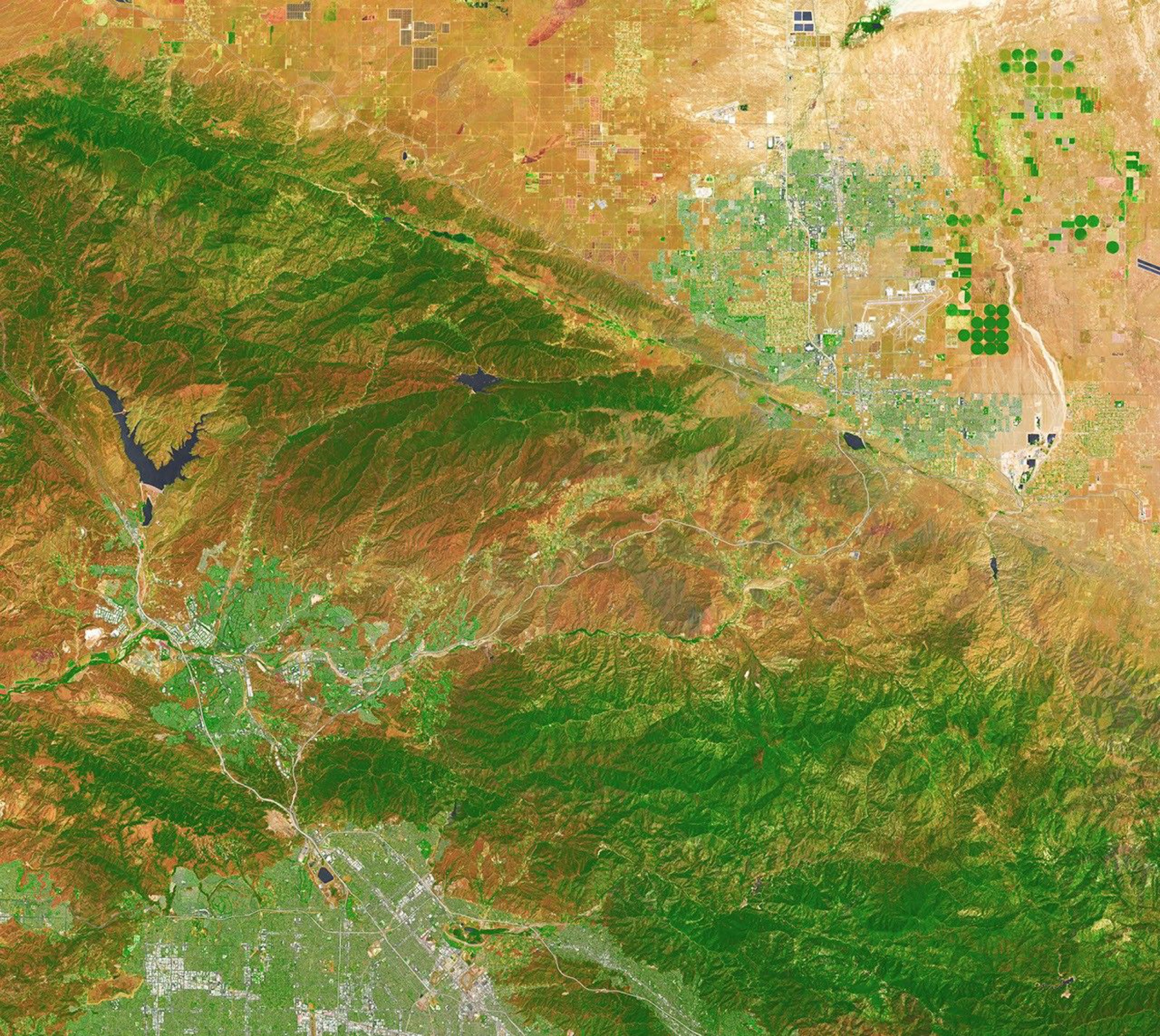 False-color Landsat view of mountains and dry hills near Agua Dulce, California, with Vasquez Rocks visible as curved gray stripes near the center