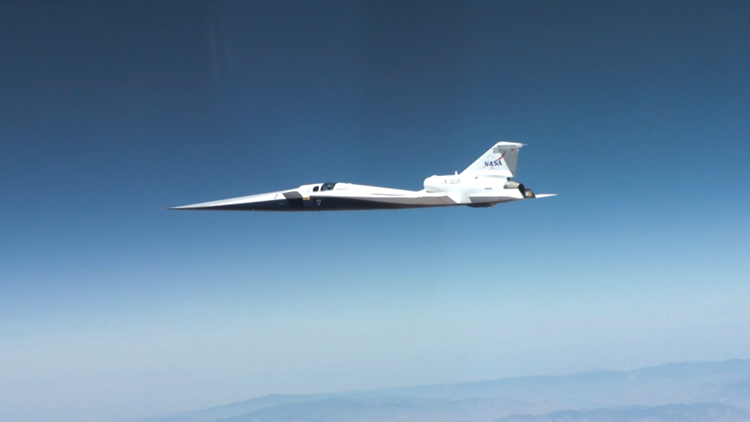 NASA's white X-59 experimental aircraft in flight during its first supersonic mission